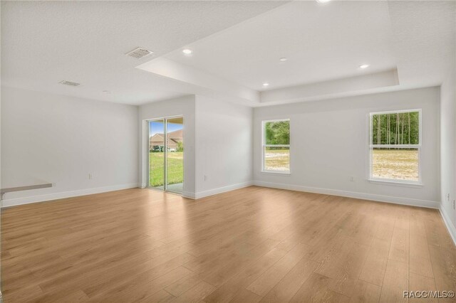 784 E Alaska Ln, Hernando, FL 34442 - empty room featuring a raised ceiling, light wood finished floors, healthy amount of natural light, and recessed lighting