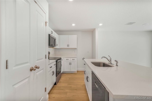 784 E Alaska Ln, Hernando, FL 34442 - kitchen with appliances with stainless steel finishes, light wood finished floors, light countertops, white cabinetry, and recessed lighting