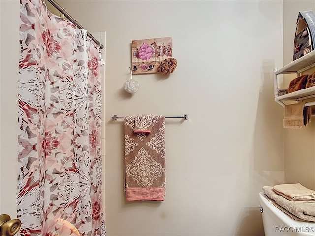 bathroom featuring a shower with curtain and toilet