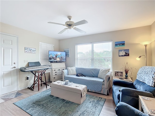 living room with light hardwood / wood-style flooring and ceiling fan