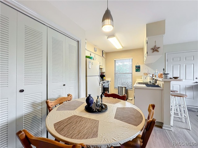 dining space featuring light hardwood / wood-style floors and sink