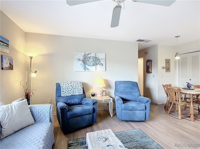 living room featuring ceiling fan and wood-type flooring