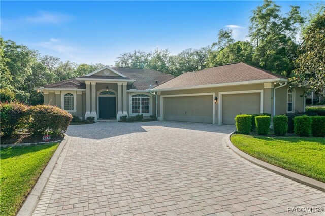 1324 Circus Ter, Hernando, FL 34442 - view of front of property featuring decorative driveway, an attached garage, a front lawn, and stucco siding