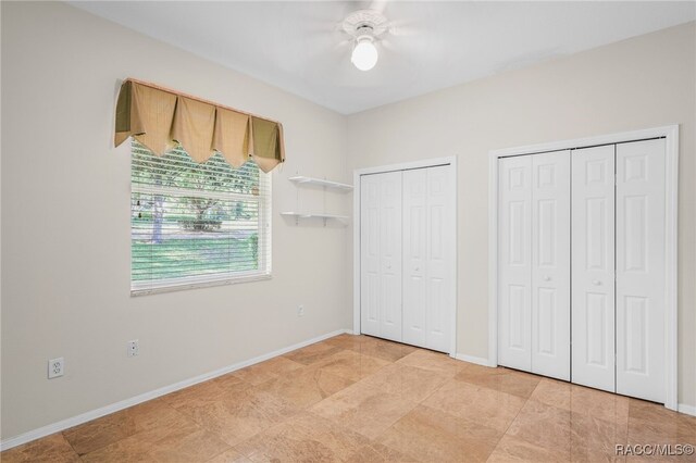 1324 Circus Ter, Hernando, FL 34442 - unfurnished bedroom featuring a ceiling fan, baseboards, and multiple closets