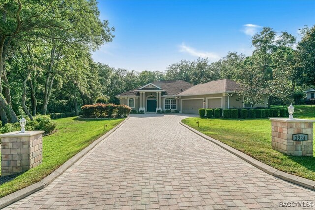 1324 Circus Ter, Hernando, FL 34442 - view of front facade with decorative driveway, a front yard, and a garage