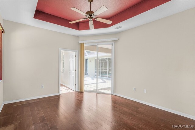 1324 Circus Ter, Hernando, FL 34442 - unfurnished room with a raised ceiling, baseboards, a ceiling fan, and wood finished floors