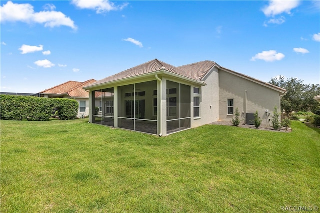 back of house with a yard and a sunroom