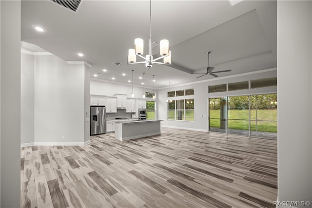 kitchen with stainless steel fridge with ice dispenser, a center island, white cabinetry, and hanging light fixtures