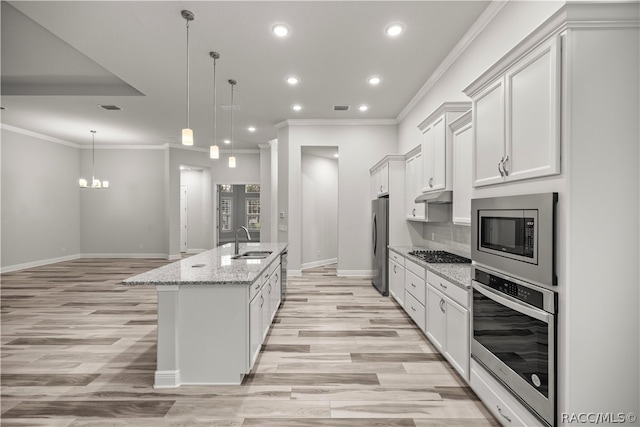 kitchen with white cabinetry, sink, hanging light fixtures, a center island with sink, and appliances with stainless steel finishes