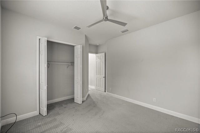 unfurnished bedroom with ceiling fan, light colored carpet, and a closet