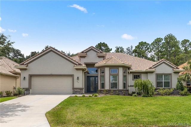 mediterranean / spanish home with a garage and a front lawn