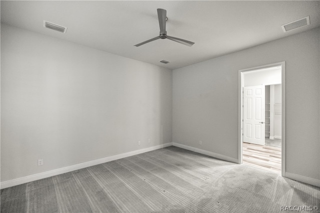 carpeted spare room featuring ceiling fan