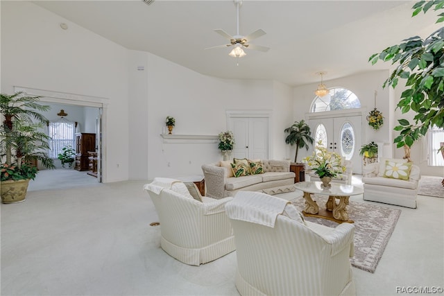 carpeted living room featuring ceiling fan, french doors, and a towering ceiling