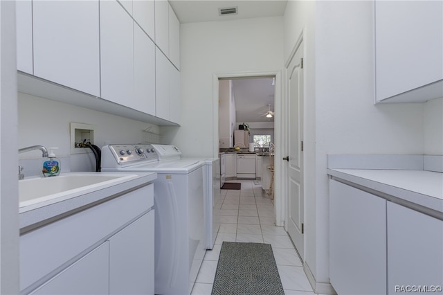 clothes washing area with cabinets, independent washer and dryer, sink, and light tile patterned floors