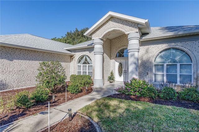 entrance to property with a lawn