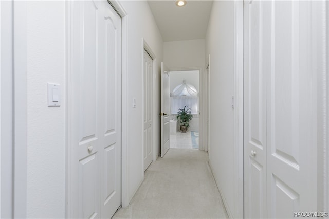 corridor featuring light colored carpet