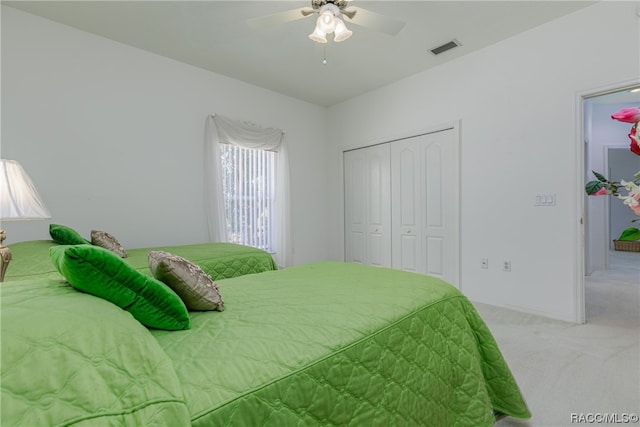 carpeted bedroom with ceiling fan and a closet