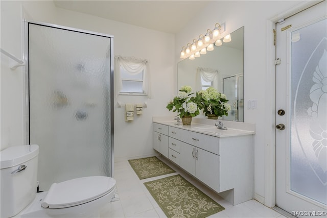 bathroom featuring tile patterned floors, vanity, a shower with shower door, and toilet