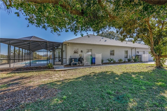 rear view of house featuring central AC, a yard, and glass enclosure