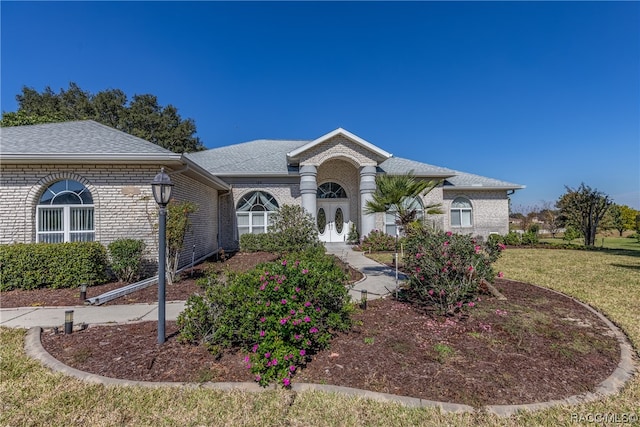 view of front of property featuring a front yard and french doors