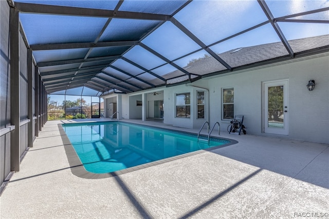 view of swimming pool with glass enclosure and a patio area