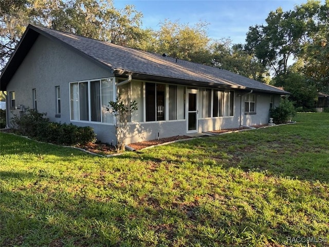3365 S Crossbill Loop, Inverness, FL 34450 - back of house featuring a yard, stucco siding, and roof with shingles