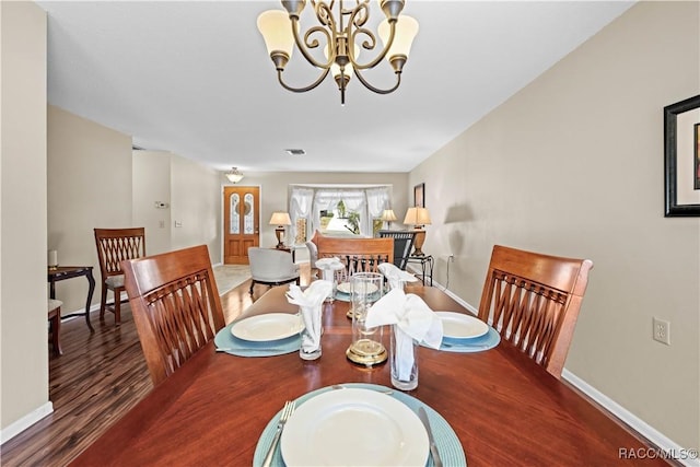 dining area featuring dark hardwood / wood-style flooring and a chandelier