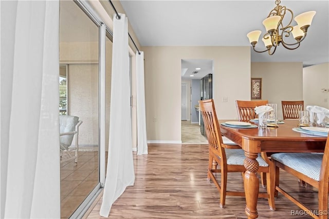 dining space featuring a notable chandelier and light hardwood / wood-style floors