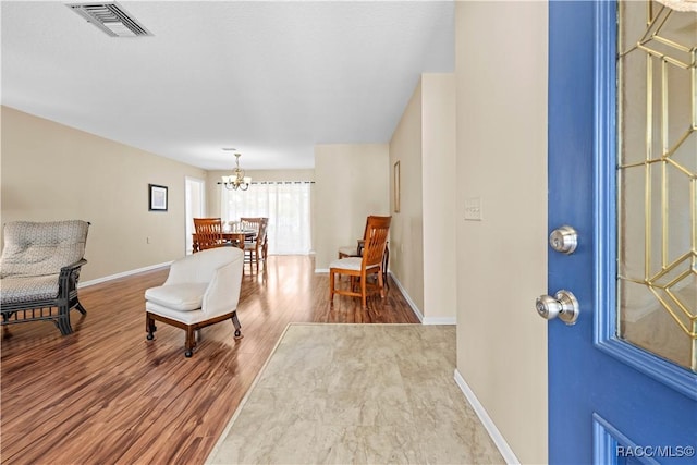 foyer entrance with a notable chandelier and wood-type flooring