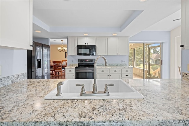 kitchen featuring white cabinetry, appliances with stainless steel finishes, a raised ceiling, and pendant lighting