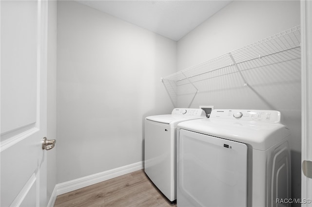 laundry room featuring light hardwood / wood-style floors and washing machine and clothes dryer