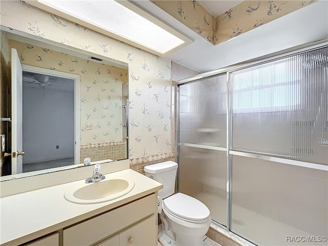 bathroom with an enclosed shower, vanity, and toilet