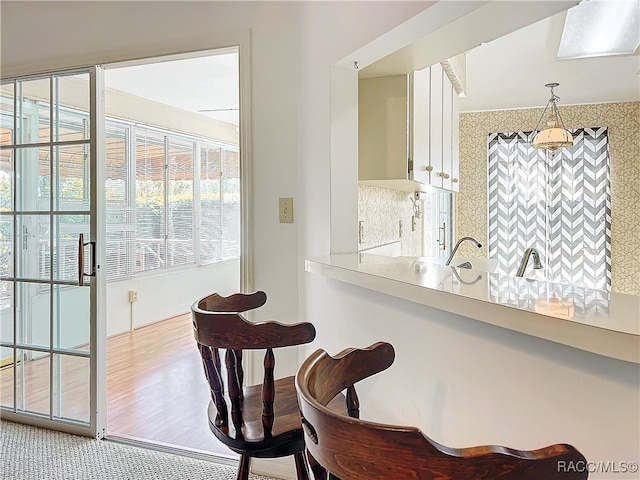 dining area featuring a skylight and wood-type flooring