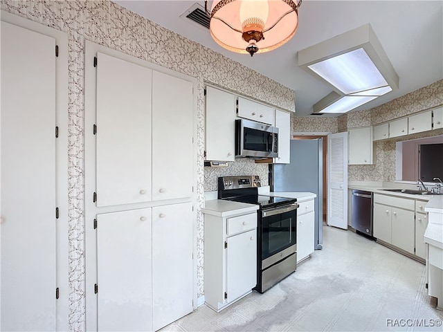 kitchen featuring white cabinets, sink, and appliances with stainless steel finishes