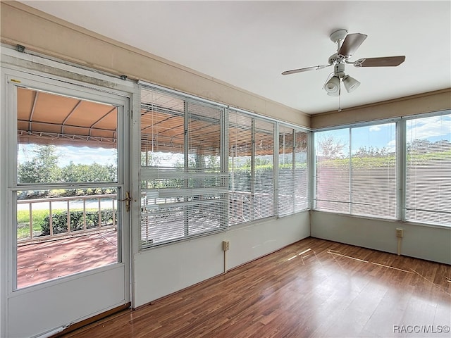 unfurnished sunroom featuring ceiling fan and a healthy amount of sunlight