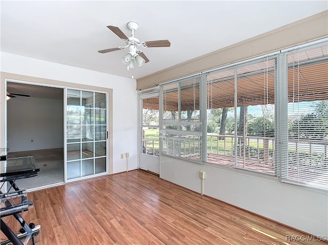 unfurnished sunroom featuring ceiling fan