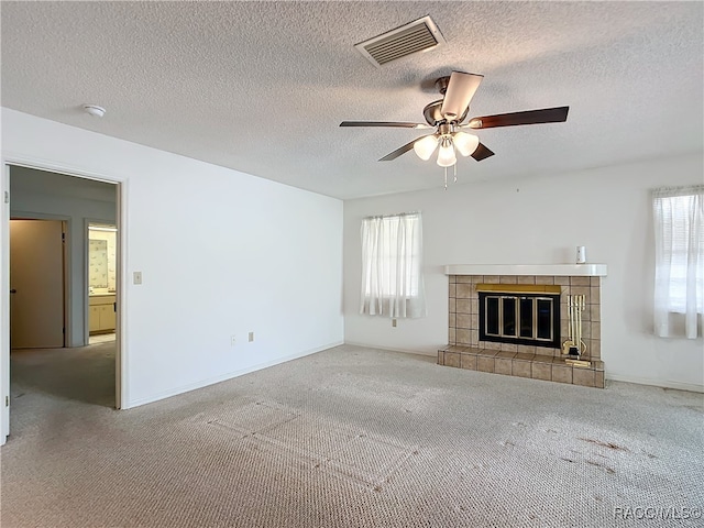 unfurnished living room with carpet flooring, plenty of natural light, and a textured ceiling