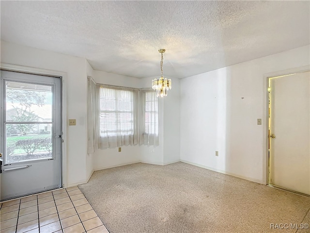 unfurnished dining area with light carpet, a textured ceiling, and a notable chandelier