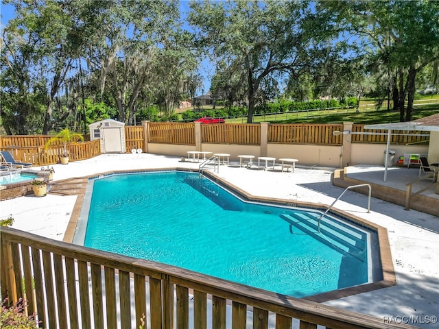 view of pool with a shed and a patio