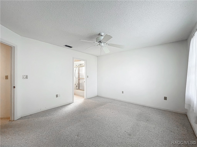 unfurnished room with ceiling fan, light colored carpet, and a textured ceiling