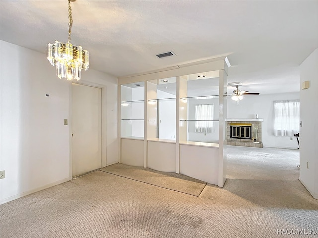 interior space with carpet flooring, a fireplace, and ceiling fan with notable chandelier