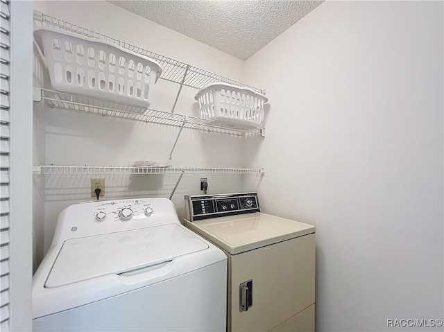 laundry room with washer and dryer and a textured ceiling