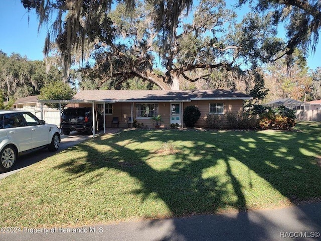 ranch-style home featuring a carport and a front yard