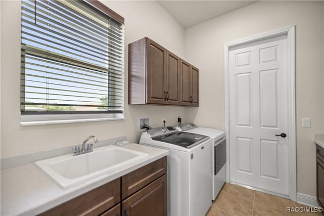 laundry area with cabinets, independent washer and dryer, sink, and light tile patterned floors