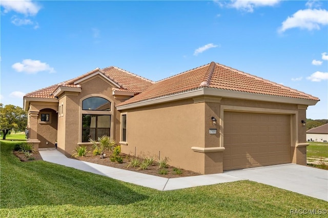 mediterranean / spanish home featuring a front yard and a garage