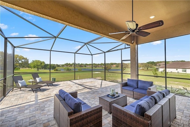 view of patio with outdoor lounge area, glass enclosure, and ceiling fan