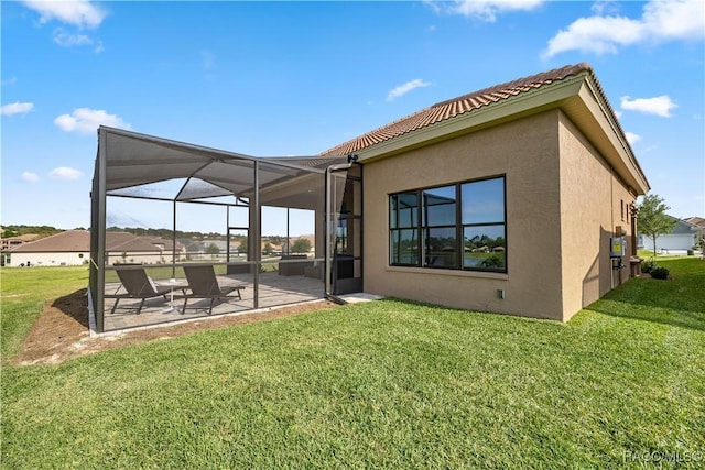 rear view of property with a lawn, a patio area, and a lanai