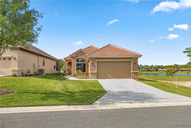 mediterranean / spanish home featuring a water view, a garage, a front lawn, and central air condition unit