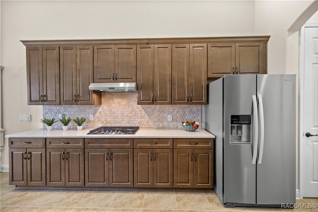 kitchen with appliances with stainless steel finishes, tasteful backsplash, and light tile patterned floors