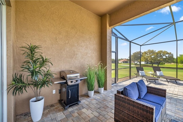 view of patio with area for grilling and a lanai